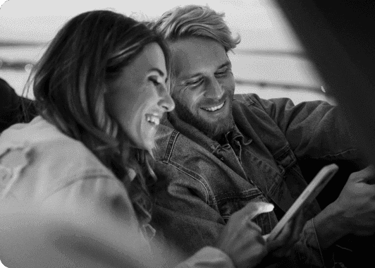 A couple looking at their phone while sitting in a car A couple looking at their phone while sitting in a car